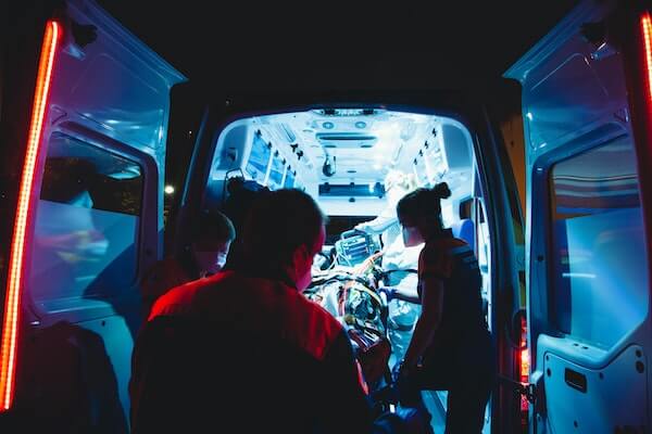 Paramedics treating a patient in the back of an ambulance at night