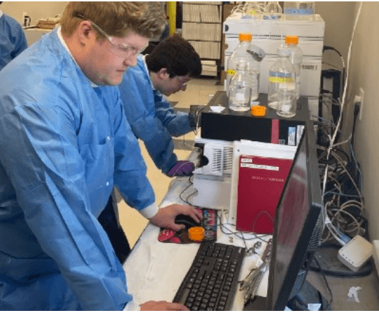 A scientist operating analytical equipment at a lab bench